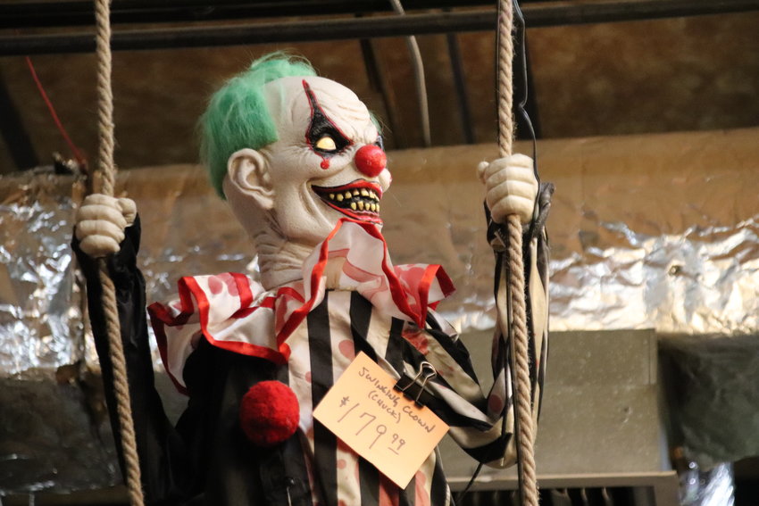 A sinister clown swings from the roof of Reinke Brothers.